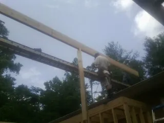 Carpenter setting a ridge beam over a new addition frame — Ice Dam Removal by Roofing Brothers in Gales Ferry