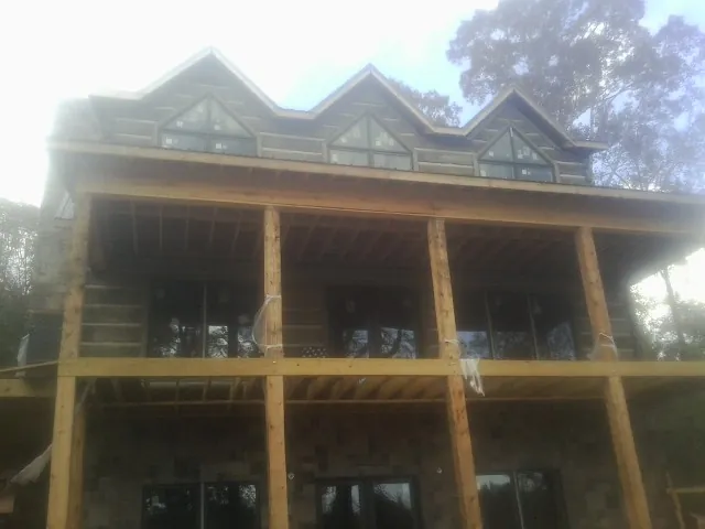 Dormers and porch framing on a large log home under construction — Roof Coating work by our crew in Gales Ferry