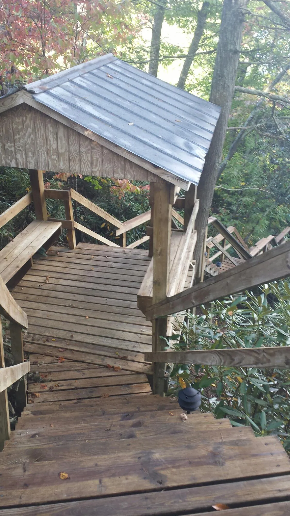 Metal roofed shelter over wooden steps on a wooded walkway — Skylight Repair & Installation work by our crew in Gales Ferry