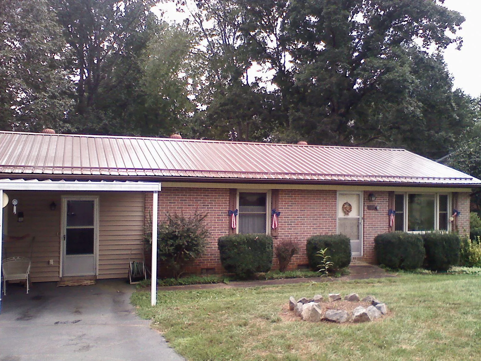 Bronze metal roof and carport on a brick ranch home — Roof Repair work by our crew in Gales Ferry